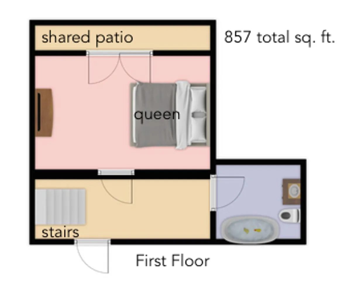 This image depicts the interior of the condo, featuring a cozy queen bed, access to a shared patio, adjacent stairs, and a glimpse of the bathroom area. The space is well-lit, inviting, and functional, reflecting comfort and thoughtful design.