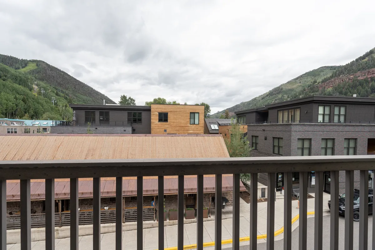 A panoramic view of the town layout with modern architectural touches and dramatic mountain backdrops. The image captures the balance between urban amenities and scenic alpine vistas.